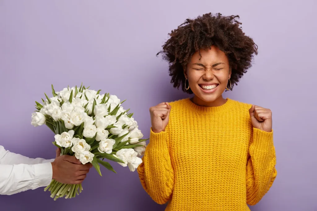 Excited woman receiving bouquet of white tulips