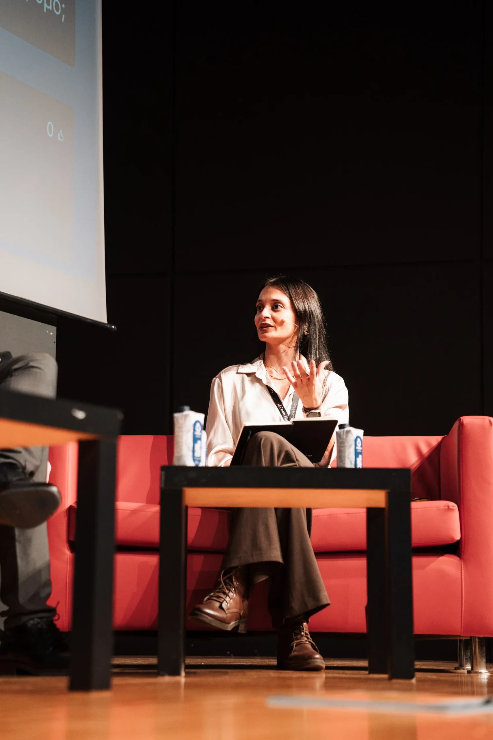 Woman speaking on stage panel at conference event
