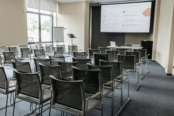 Empty conference room with chairs and projection screen