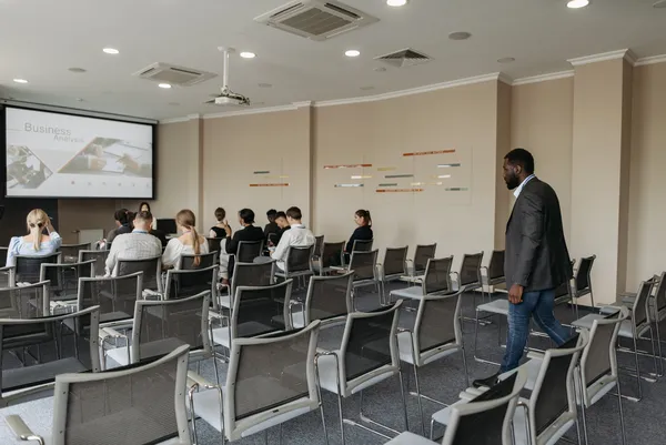 Business analyst presenting to small audience in conference room